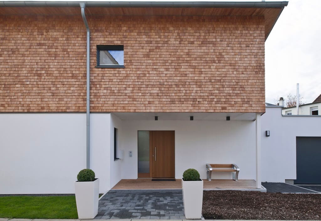 Einfamilienhaus modern mit überdachtem Hauseingang, Holz Fassade & Garage - Fertighaus Designhaus Bullinger von Baufritz - HausbauDirekt.de