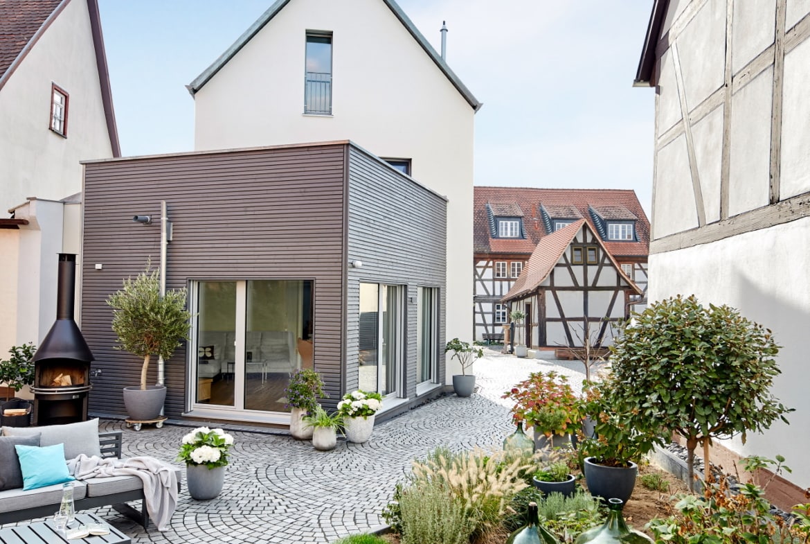 Modernes Einfamilienhaus mit Satteldach Architektur, Erker Anbau mit Holz Putz Fassade - Fertighaus bauen Ideen ökologisches Baufritz Haus STADTHAUS EHRMANN - HausbauDirekt.de