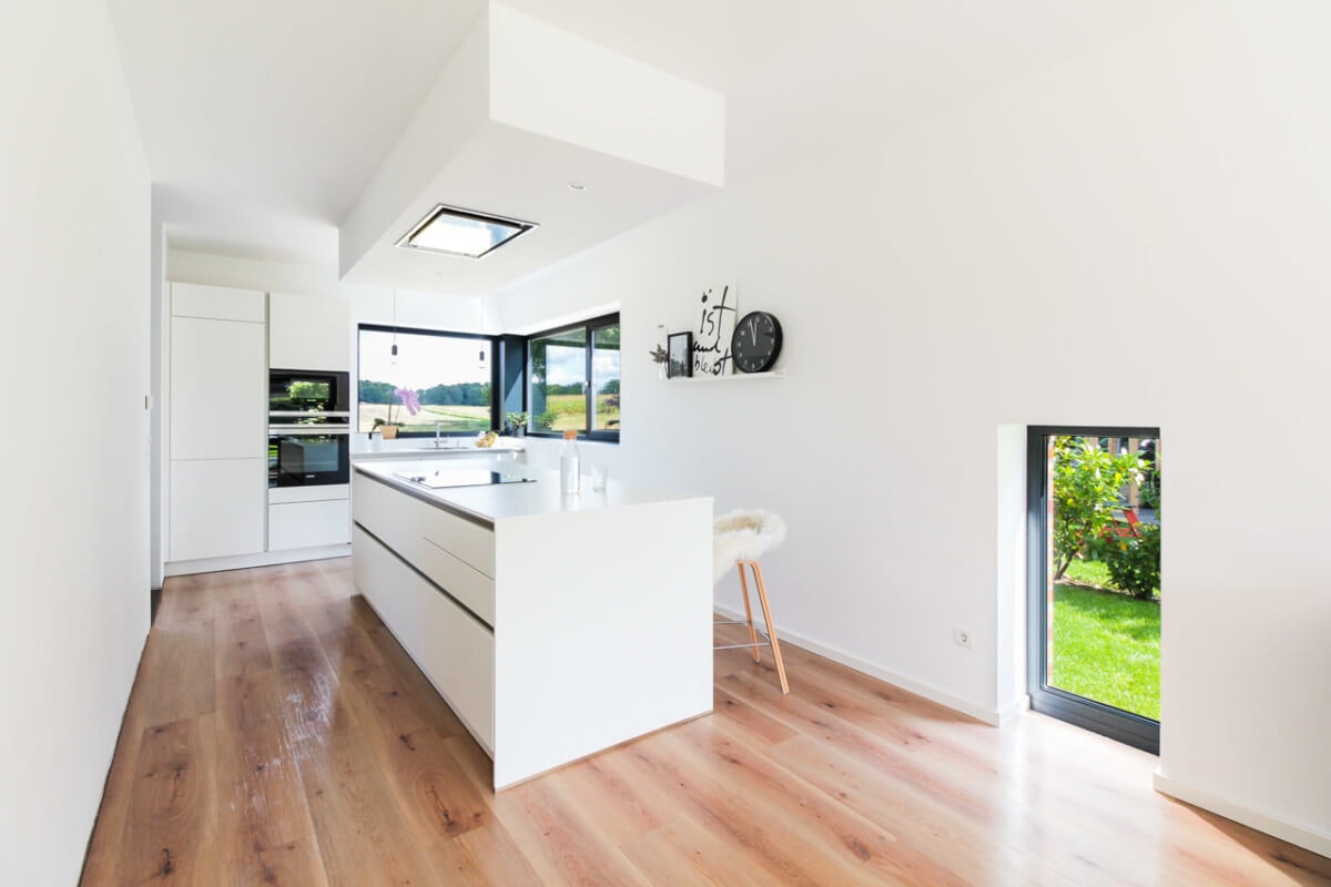 Offene Küche modern minimalistisch weiss mit Kochinsel - Inneneinrichtung Haus Design Ideen innen Massivhaus Vario-Haus 160 von ECO System HAUS - HausbauDirekt.de