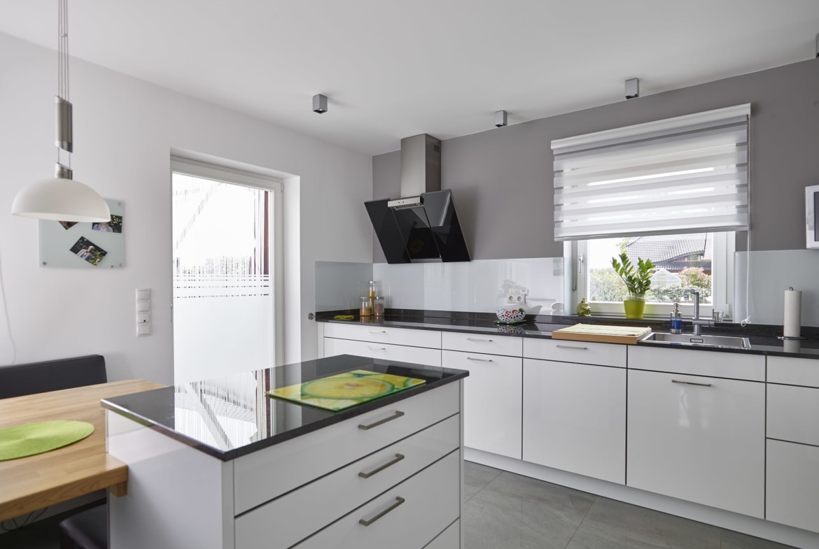 Küche modern weiß mit Insel & Tisch - Inneneinrichtung Ideen Einfamilienhaus Kastanienallee von GUSSEK HAUS - HausbauDirekt.de