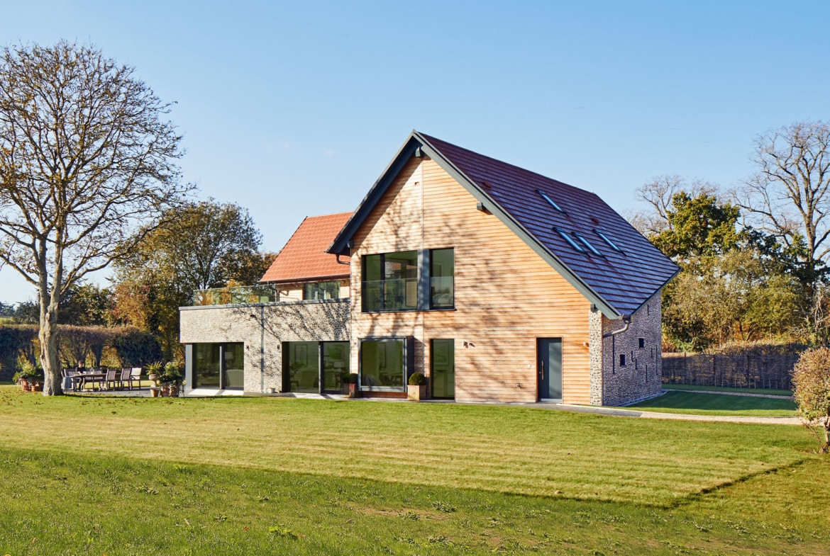 Modernes Holzhaus mit Satteldach und Holz Fassade bauen -Einfamilienhaus Ideen Fertighaus Baufritz Landhaus LLOYD WEBBER - HausbauDirekt.de