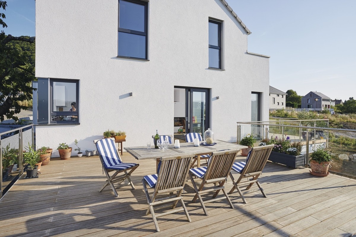 Terrasse Einfamilienhaus in Hanglage mit Holz Dielen Belag & Glasgeländer - Haus bauen Design Ideen WeberHaus Fertighaus Sunshine 310 - HausbauDirekt.de